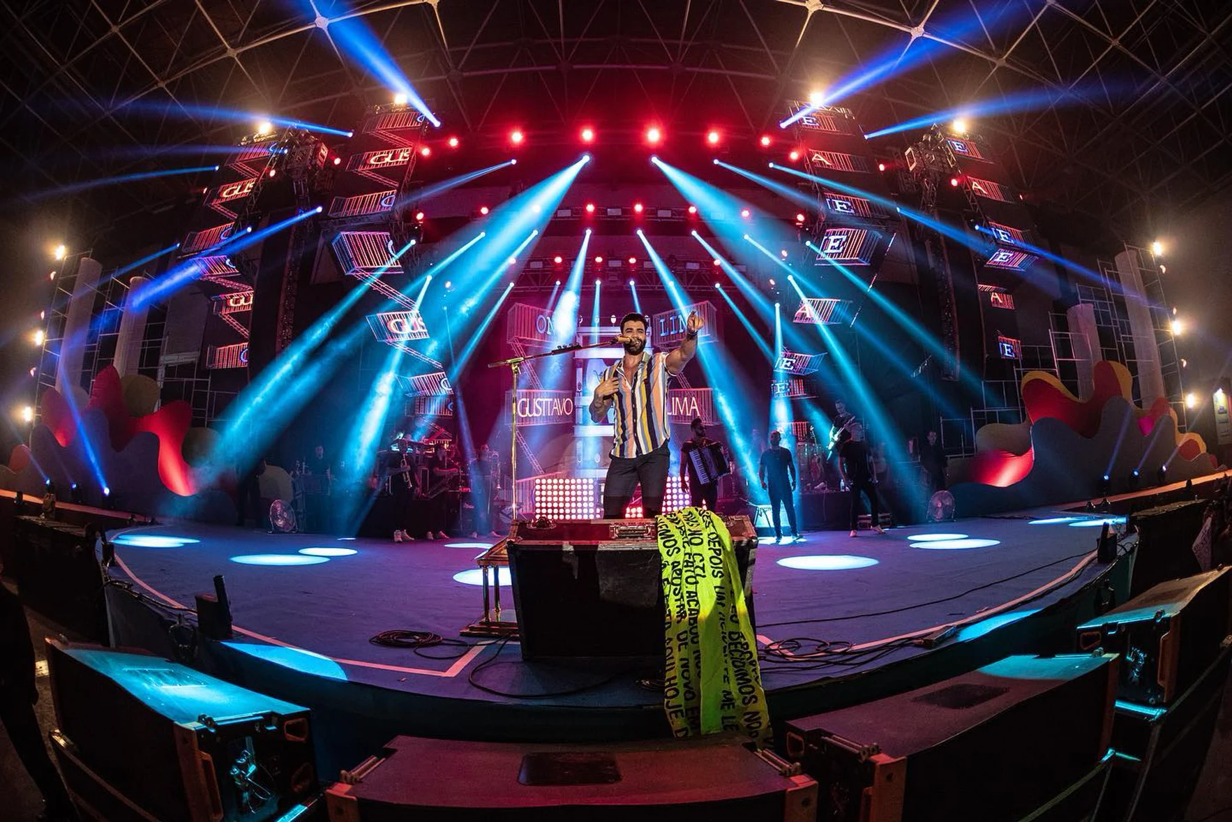 Show ao vivo com palco iluminado em vermelho e azul